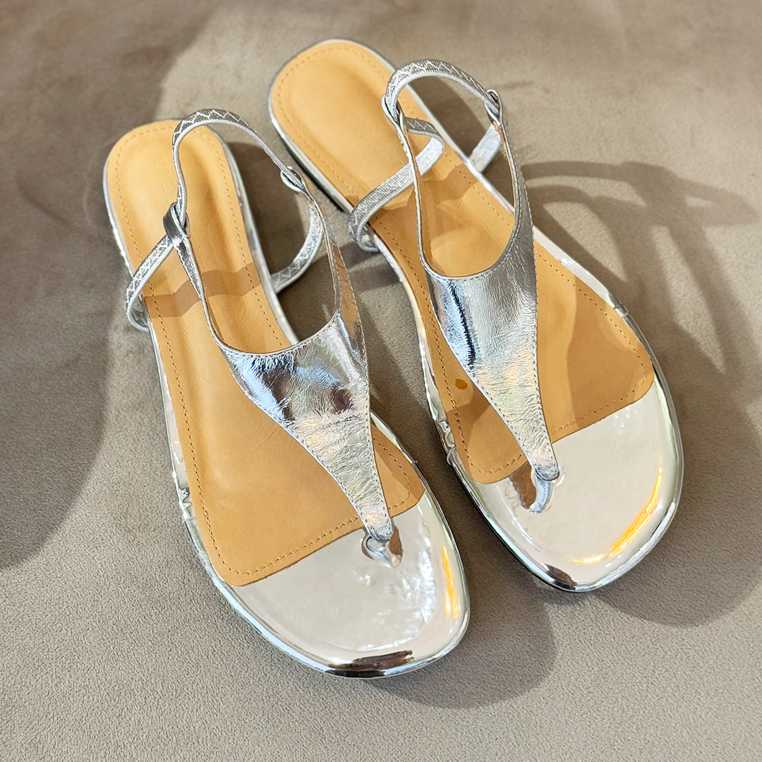 Un par de sandalias color plateado. 