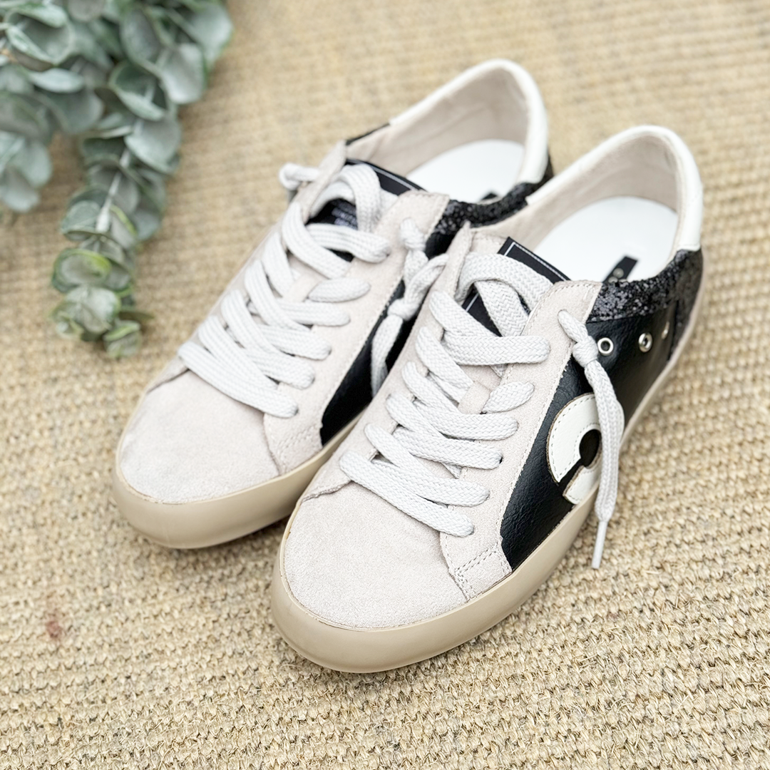 Un par de zapatillas color blanco con negro a los lados.